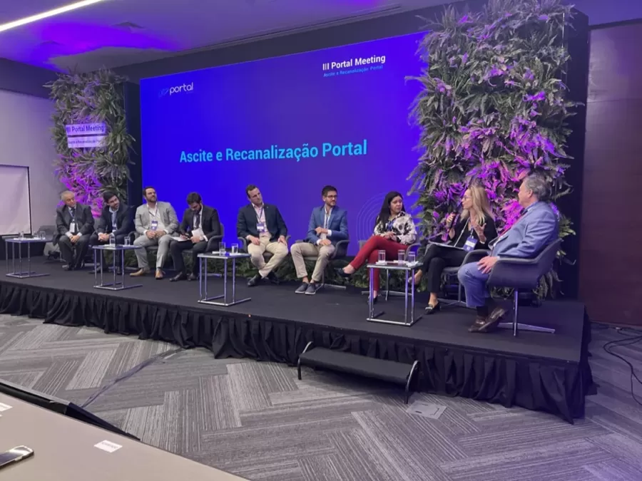Mesa de discussão no palco do III Portal Meeting, com o tema Ascite e Recanalização Portal no telão